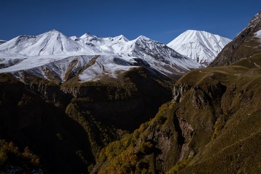 A landscape view of the beautiful rocky mountains covered with snow under a blue sky on a sunny day