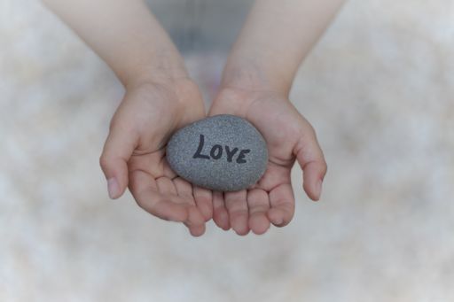 A child holding a rock with love written on it - great for a background