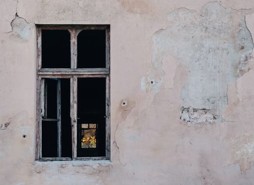 The window of a building surrounded by the cracks of the wall