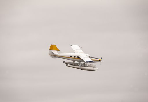 A closeup picture of a seaplane flying over the sky