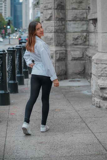 A vertical shot of a Hispanic girl posing for the camera outside in United States