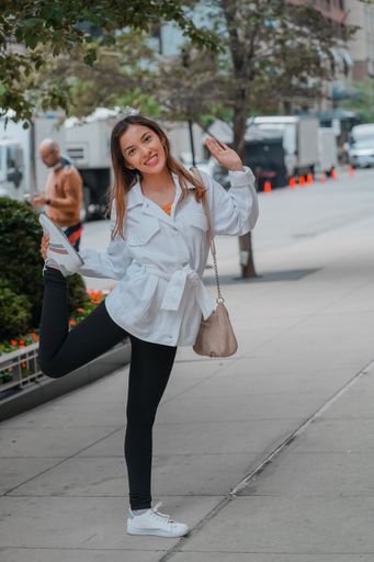 A vertical shot of a Hispanic girl posing for the camera outside in United States
