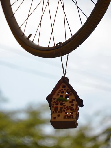 A house for birds hanging on the old bicycle wheel