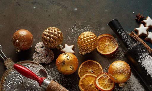 Festive composition with Christmas cookies, baubles, cinnamon sticks, nuts, and baking tools on the grunge surface