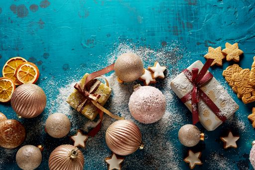 Tasty Christmas cookies, baubles, and gift boxes on the grunge surface; blue background with a copy space