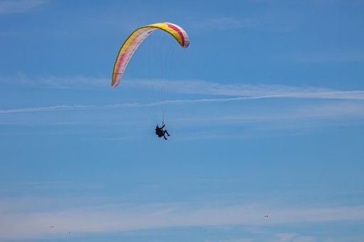 Egmond ann Zee, Netherlands - July 18, 2019: a paraglider with a red, white and yellow parachute