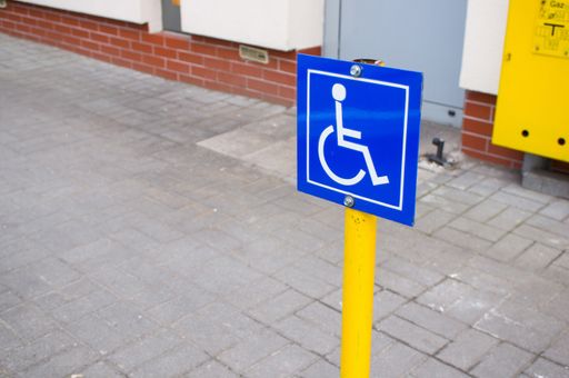 A close up of a Blue sign showing a parking spot for disabled people