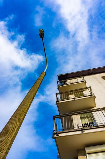 A low-angle view of a lamp post and apartment building with balconies in the Stare Zegrze district, Poznan, Po