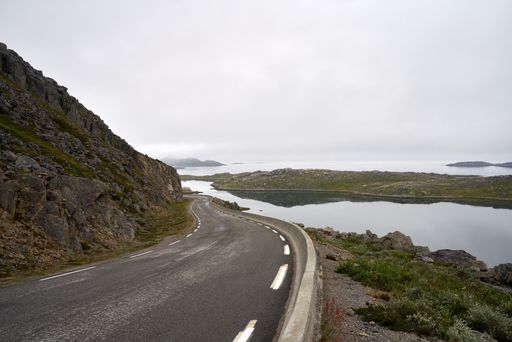An empty road in Nordkapp, Norway under a cloudy sky