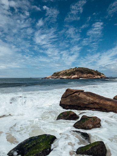 A tropical island with a rocky beach on a sunny day