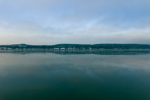 A beautiful view of the horizon of cloudy blue sky reflecting on water in Port of Klaipeda, Lithuania
