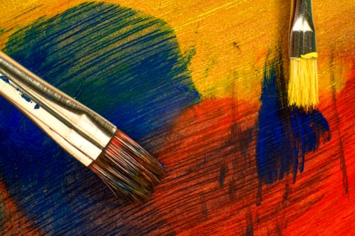 A colorful palette with two brushes on it