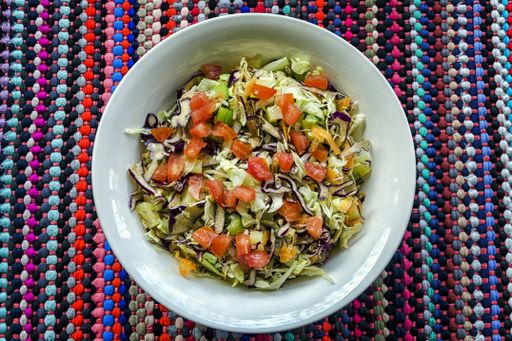 An overhead shot of tomato, red cabbage,  lettuce, and carrot salad