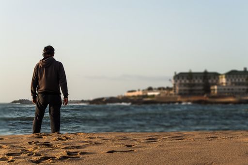 A close-up shot of middle age man looking out the sea from a beach