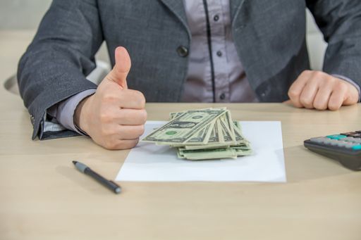 A young businessman working from his office and counting cash money