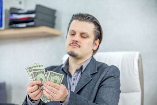 A young businessman working from his office and counting cash money