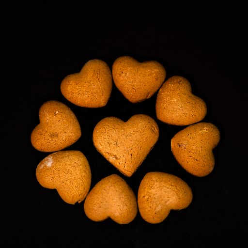 A top view of 9 Heart-Shaped cookies on black background. National Cookie Day on a black background