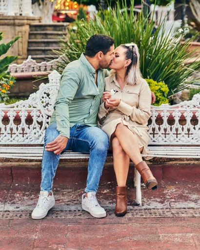 Young Latin male and female couple in love giving each other a kiss between 25 and 35 years old