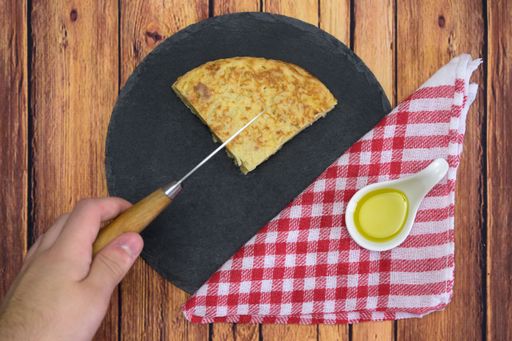 A tasty cake with an egg yolk and oil on a wooden table
