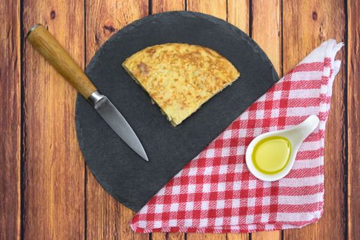A tasty cake with an egg yolk and oil on a wooden table