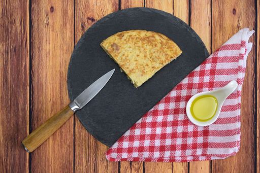 A tasty cake with an egg yolk and oil on a wooden table