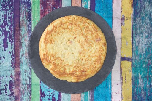 A closeup shot of a round omelet on a wooden table