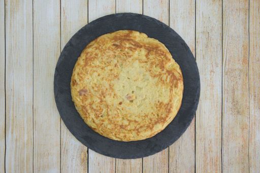 A closeup shot of a round omelet on a wooden table