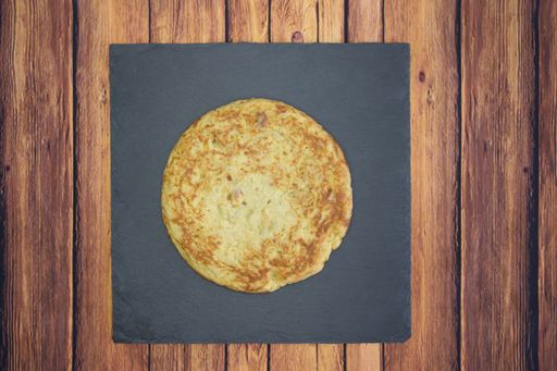 A closeup shot of a round omelet on a wooden table