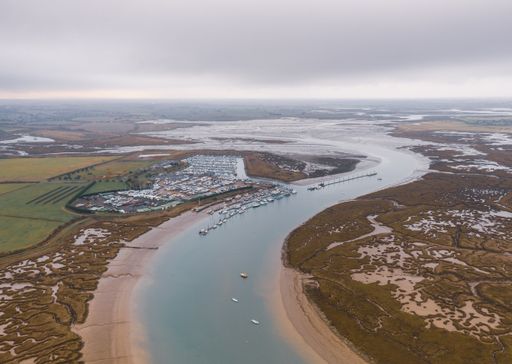 An aerial shot of a wide river slowly flowing through the vast valley