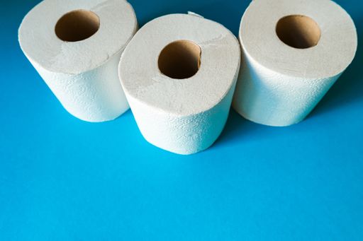 Several rolls of toilet paper against a cyan blue modern background. Concept for shortages of household goods during a global virus pandemic