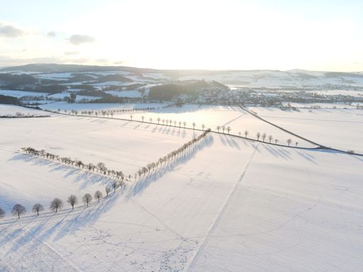 Aerial view of a snowy winter landscape at sunset. Snow covered countryside in Lower Saxony, Germany.
