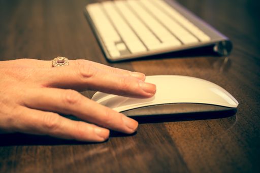 A closeup shot of the hand on the mouse and the keyboard on the table