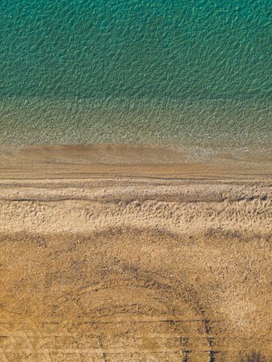An aerial view of an empty sand beach