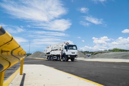 A white truck crane parked on a road while in the construction area