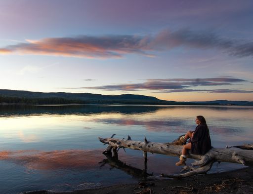 A beautiful Caucasian woman resting in Jenny Lake at Grand Teton National Park, USA during sunset