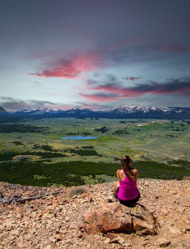 A rear view of a woman hiker resting in Yellowstone National Park, USA during sunset