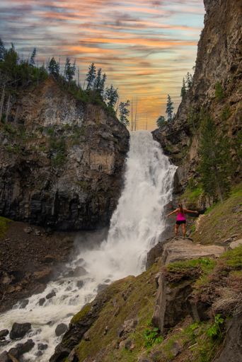 A rear view of a woman hiker resting in Yellowstone National Park, USA during sunset