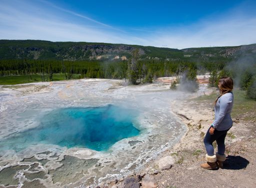A young woman near a hot spring in Yellowstone National Park, the USA