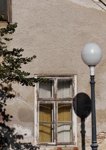 A vertical shot of an old weathered damaged grungy window of a house