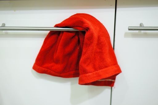 A closeup shot of a red towel hanging on a rack