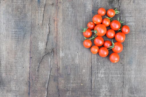 A top view of red cherry tomatoes isolated on a wooden background