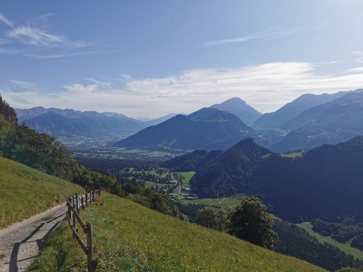 A beautiful shot of the Swiss Alps with green trees in summer under a blue cloudy sky