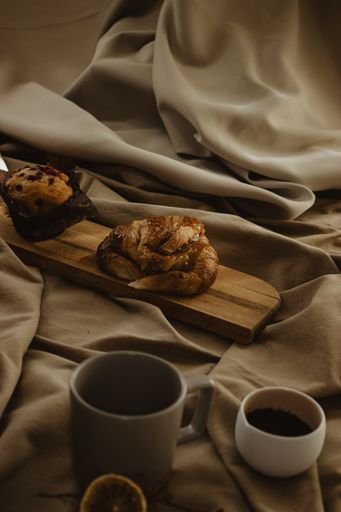 A vertical shot of varied Mediterranean breakfast of coffee beans with croissant and muffin
