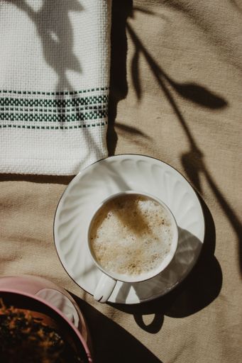 A vertical shot of a cup of foamy coffee on a fabric surface