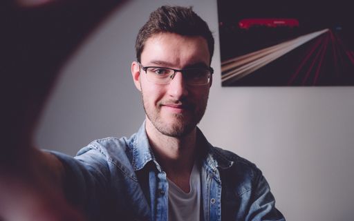 Young handsome man makes a selfie in his living room. Social distancing and isolation due to the ongoing coronavirus pandemic (Covid-19).