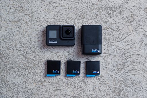 Action camera flatlay with batteries and charger with a textured backdrop, Brasov, Romania