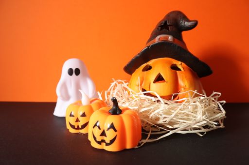 A closeup shot of carved pumpkins and a ghost figure - Halloween concept