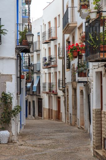 A narrow street through the buildings in Tortosa, Spain
