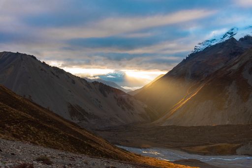 The snowy Tilicho Peak mountain in the Nepalese Himalayas under a blue cloudy during the sunse