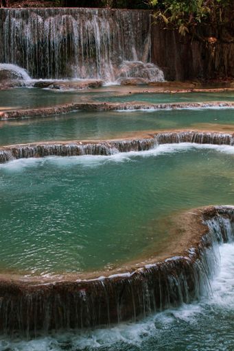 A vertical shot of a beautiful waterfall flowing over the cascade